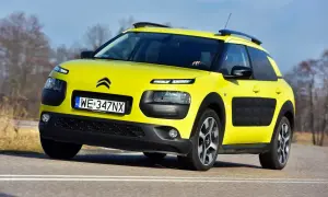 Żółty Citroen C4 Cactus na drodze. Kierowca testuje auto, zbierając pozytywne opinie o jego komforcie i oryginalnym wyglądzie.