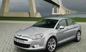 Srebrny Citroen C5 na tle mostu. Wiele osób chwali ten model, a opinie o Citroen C5 są zazwyczaj pozytywne.