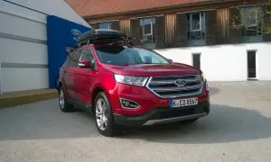 Czerwony Ford Edge z boxem dachowym, idealny na rodzinne wyjazdy. Sprawdź jego imponujące ford edge wymiary!