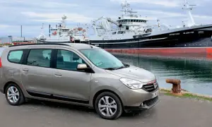 Brązowy Dacia Lodgy zaparkowany przy nabrzeżu, w tle wielkie statki rybackie.