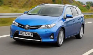 Niebieski Toyota Auris 2015 na drodze, z rozmytym tłem.