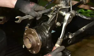 Mechanik dokręca śruby przy piaście, gdzie znajduje się łożysko w kole.