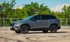 Szary Renault Austral na tle zieleni. Wiele osób szuka **Renault Austral opinie** przed zakupem.