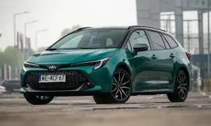 Zielona Toyota Corolla Touring Sports hybrid na mokrej nawierzchni.