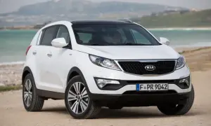 Biały Kia Sportage 2014 na plaży, gotowy na przygodę nad morzem.
