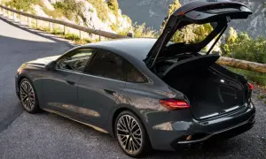 Szary Audi RS 6 Avant, sportowy coupe z otwartym bagażnikiem, stoi na górskiej drodze.