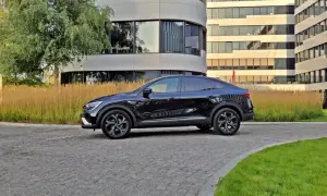 Elegancki, czarny Renault Arkana na tle nowoczesnych budynków. Sprawdź jego wymiary i styl.