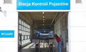 Pracownik sprawdza samochód na podnośniku. Dowiedz się, ile kosztuje przegląd samochodu w stacji kontroli pojazdów.
