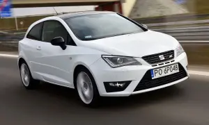 Biały Seat Ibiza 1.4 benzyna pędzi po drodze, z czarnym dachem i felgami.