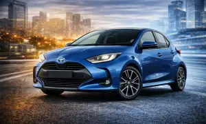 Niebieski Yaris 4 na tle rozświetlonego miasta nocą. Dynamiczna sylwetka i nowoczesne linie podkreślają jego miejski charakter.