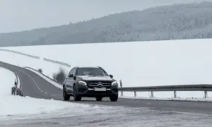 Czarny Mercedes GLE jedzie po ośnieżonej drodze. Jego wymiary pozwalają na pewne poruszanie się w trudnych warunkach.