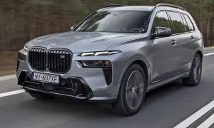 Szary BMW X7 M Sport pędzi po drodze. Sprawdź aktualną bmw x7 cena i dowiedz się więcej o tym luksusowym SUV-ie.
