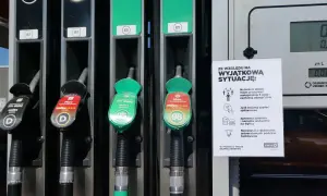 Dwa dystrybutory paliwa, jeden z oznaczeniem 95, drugi z 98. Obok tabliczka z zasadami bezpieczeństwa.
