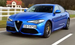 Niebieskie Alfa Romeo Giulia w ruchu. Wiele pozytywnych alfa romeo giulia opinie potwierdza jej sportowy charakter.