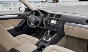 Wnętrze VW Jetta MK6 z jasną tapicerką, nawigacją i automatyczną skrzynią biegów.