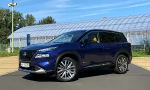 Niebieski Nissan X-Trail na tle hali sportowej. Wiele osób szuka nissan x trail opinie, ten SUV może być dobrym wyborem.