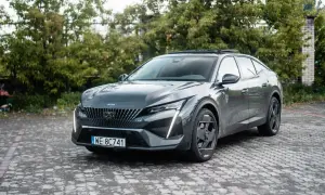 Szary Peugeot 408 na brukowanym podjeździe. Wiele osób szuka peugeot 408 opinie, ten model robi wrażenie.
