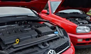 Dwa czerwone Volkswageny z otwartymi maskami. Silnik TDI w nowszym modelu, starszy model z przodu. Oba gotowe na paliwo diesel.
