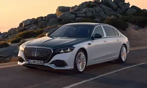 Elegancki, dwukolorowy Mercedes-Maybach sunie po górskiej drodze o zachodzie słońca.