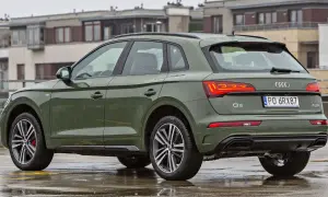 Zielony Audi Q5 na mokrym parkingu. Sprawdź aktualną audi q5 cena i wyposażenie.
