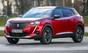 Czerwony Peugeot 2008 na zewnątrz. Wiele osób szuka peugeot 2008 opinie, by dowiedzieć się więcej o tym modelu.