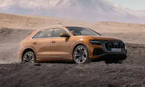 Pomarańczowy Audi Q8 w terenie, gotowy na przygodę. Sprawdź aktualną audi q8 cena i odkryj jego możliwości.