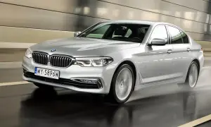 Srebrne BMW 520d xDrive w ruchu, z rozpryskującą się wodą spod kół, w nowoczesnym tunelu.