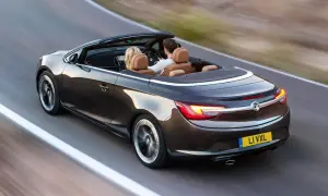 Para podróżuje lśniącym, ciemnobrązowym **Opel cabrio** po krętej drodze.