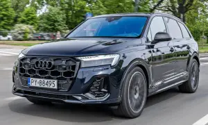 Ciemny Audi Q7 w ruchu ulicznym. Zwróć uwagę na jego imponujące audi q7 wymiary, które zapewniają przestronne wnętrze i stabilność na drodze.
