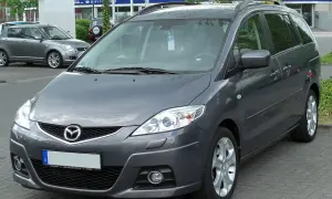 Szary minivan Mazda 5 na parkingu. Wiele osób szuka mazda 5 opinie, ten model jest dobrym wyborem.