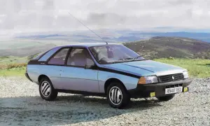 Jasnoniebieski Renault Fuego z lat 80. stoi na szutrowej drodze, z widokiem na pagórkowaty krajobraz i chmurne niebo.