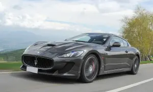 Szary Maserati GranTurismo na krętej drodze. Marzysz o takim aucie? Sprawdź aktualną maserati cena i spełnij marzenie.