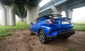 Niebieski Toyota C-HR 2018 zaparkowany pod mostem.