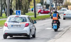 Nauka jazdy na motorowerze, czyli ile kosztuje prawo jazdy AM. Na drodze auto z literą "L" i motocyklista z kamizelką odblaskową.