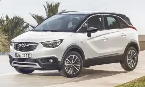 Biały Opel Crossland z czarnym dachem, zaparkowany na tarasie z palmami w tle. Wiele pozytywnych opinii o tym modelu.