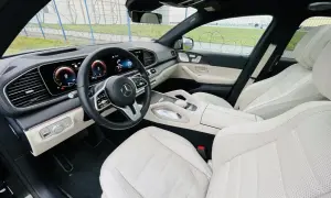 Wnętrze luksusowego Mercedesa GLE 400d z jasną, skórzaną tapicerką i nowoczesnym kokpitem.