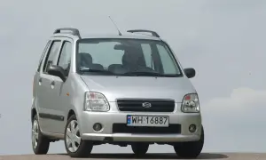 Srebrny Suzuki Wagon R+ z polskimi tablicami rejestracyjnymi WH 16887, zaparkowany na tle jasnego nieba.