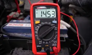 Multimetr pokazuje 14.53V, co jest kluczowe, jak sprawdzić alternator. Pomiar napięcia na akumulatorze podczas pracy silnika.