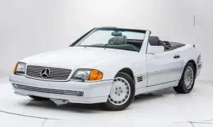 Biały kabriolet Mercedes-Benz SL500 z lat 90. z szarym wnętrzem, gotowy na letnią przejażdżkę.