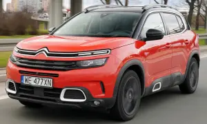 Czerwony Citroen C5 Aircross na drodze. Wiele pozytywnych citroen c5 aircross opinie potwierdza jego komfort i styl.