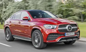 Czerwony Mercedes-Benz GLE Coupe, model gle amg, pędzi po drodze, za kierownicą siedzi kierowca w okularach.
