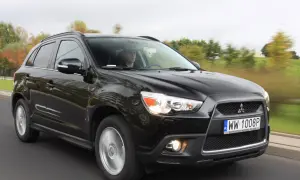 Czarny Mitsubishi ASX 1.6 benzyna w ruchu, z kierowcą za kierownicą.