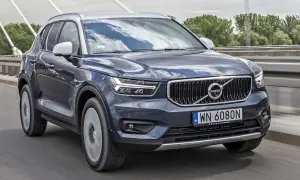 Ciemnoszary Volvo XC40 jedzie po moście. Sprawdź aktualną volvo xc40 cena i dostępne wersje.