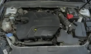 Silnik Duratorq 2.0 TDCI w Fordzie Mondeo MK5. Widoczny akumulator, zbiornik płynu chłodniczego i elementy układu dolotowego.