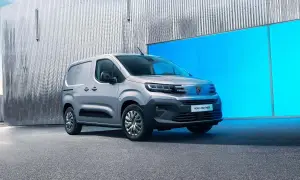 Nowy Peugeot e-Partner, srebrny van, stoi przed błyszczącą, falistą ścianą i jaskrawoniebieskim panelem.