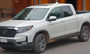 Biały Honda Ridgeline z błotem na progach, gotowy na przygodę.