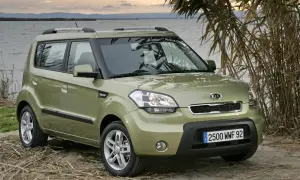 Zielony Kia Soul na tle jeziora i trzcin. Wiele osób szuka kia soul opinie przed zakupem.