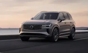 Szary Volvo XC90 w ruchu, z pięknym zachodem słońca w tle. Wiele osób szuka volvo xc90 opinie przed zakupem.