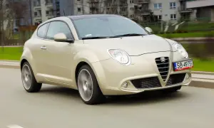 Złoty Alfa Romeo MiTo w ruchu miejskim. Wiele osób chwali ten model za wygląd, co potwierdzają alfa romeo mito opinie.