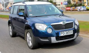 Niebieska Skoda Yeti na drodze. Kierowca w środku. Wiele pozytywnych skoda yeti opinie o tym modelu.